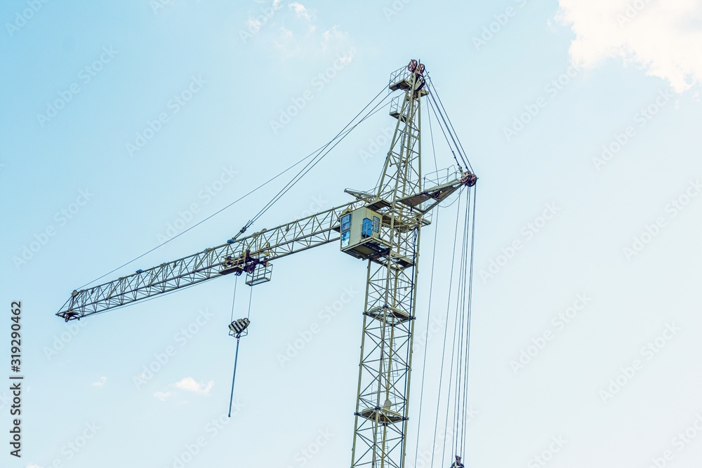 Building crane on blue sky background with clouds