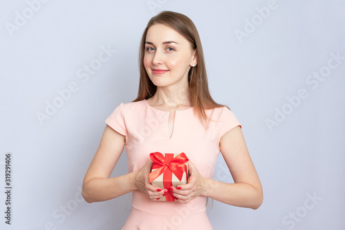 Young girl received a gift. Portrait, grey background