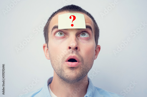Amazed man with sticker with a question mark. The concept of thinking, portrait