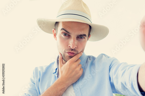 Wallpaper Mural Selfie of narcissistic man in hat, attractive man uses a mobile phone outdoors, portrait, toned Torontodigital.ca