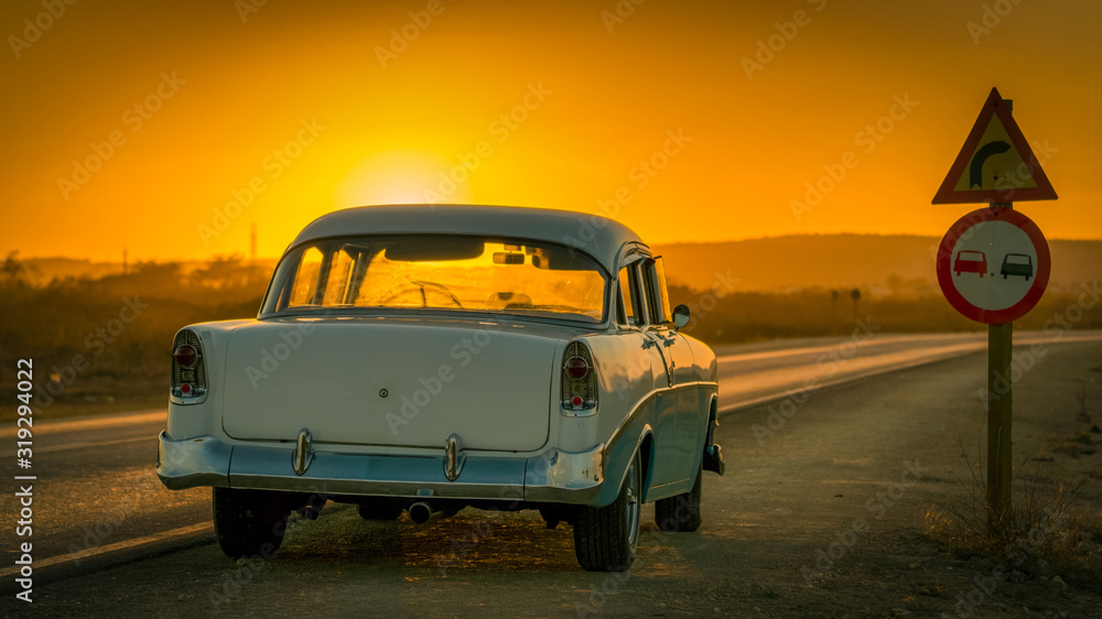 Fototapeta premium colorful baby-blue cuban classic car in sunset light, cuba