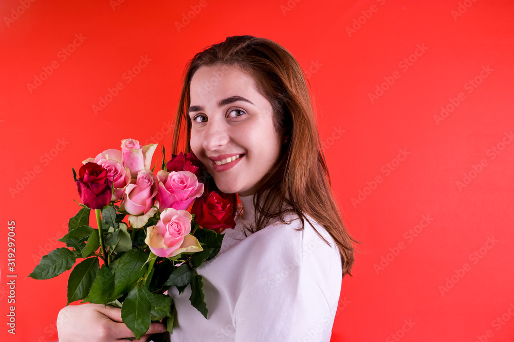 The concept of Valentine's Day and Women's Day. Happy young girl holding a bouquet of roses. The concept of Valentine's Day and Women's Day. Happy young girl holding a bouquet of roses.