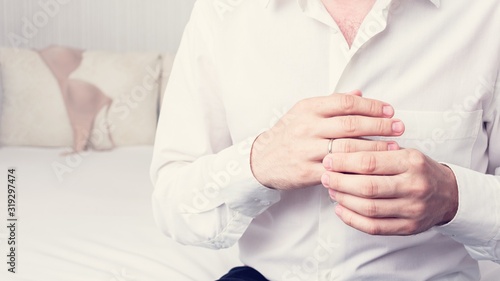 Unfaithful man with wedding ring, mistress's underwear in the background, closeup, cropped black and white image. The concept of infidelity in marriage, 16:9