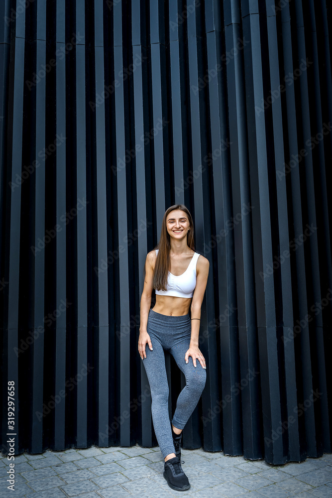 Sportive and very slim woman posing outdoors on abstract background Sportive and very slim woman posing outdoors on abstract background