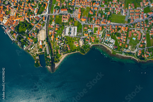 Aerial view of Como lake, Dongo, Italy. Coastline is washed by blue turquoise water