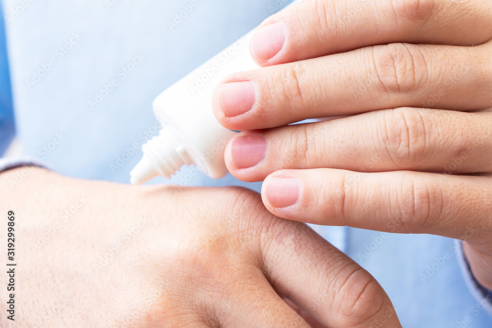 Man uses hand cream, women's hands, close up, toned Man uses hand cream, women's hands, close up, toned