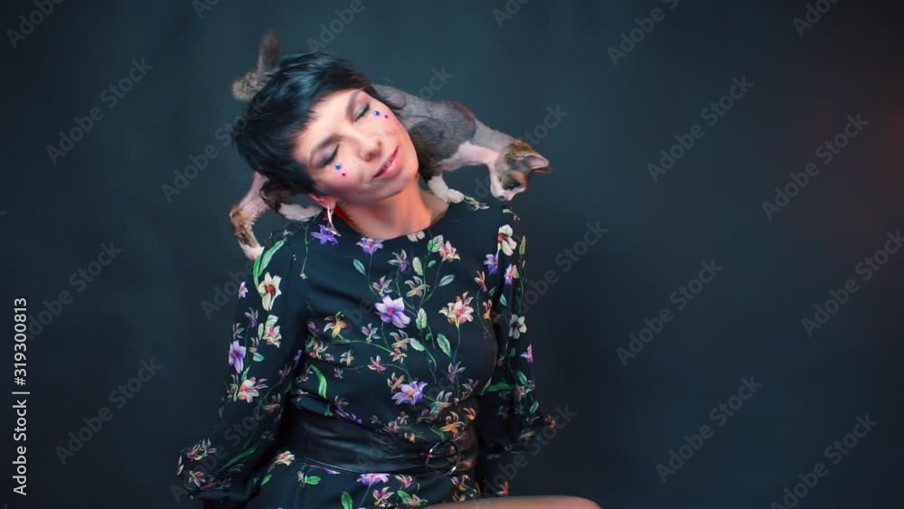 Beautiful woman with gloves in her arms posing with a Devon Rex Beautiful woman with gloves in her arms posing with a Devon Rex