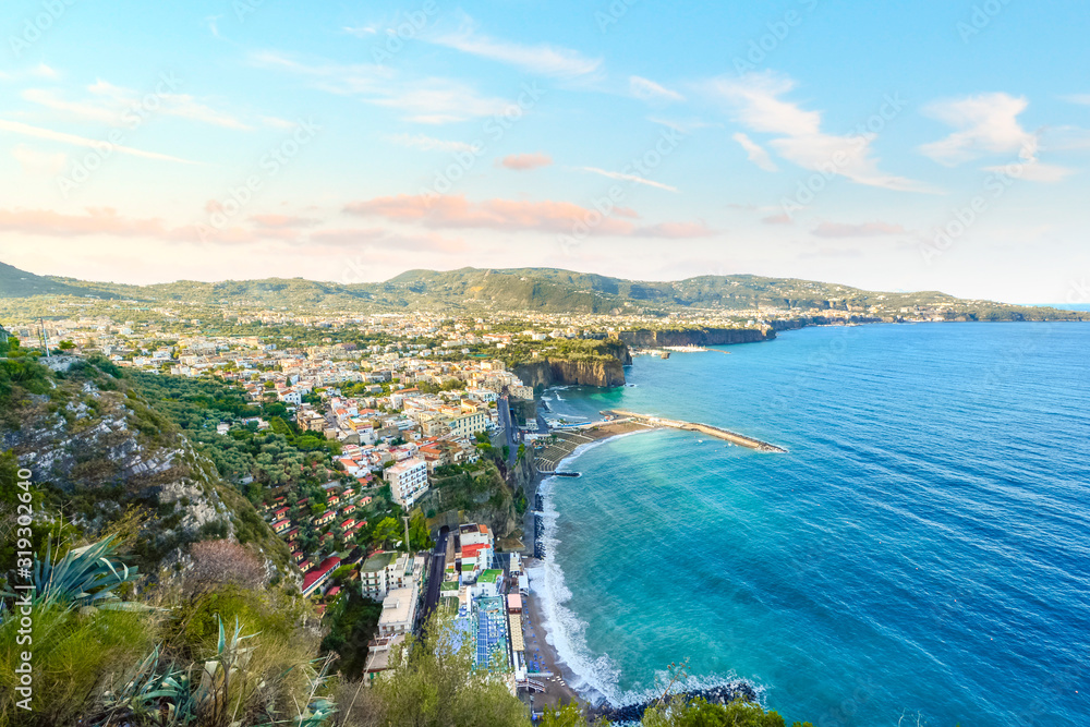 View from the Amalfi Coast drive over the town of Sorrento, Italy, the Mediterranean Sea, and the Sorrentina Peninsula on a summer morning.