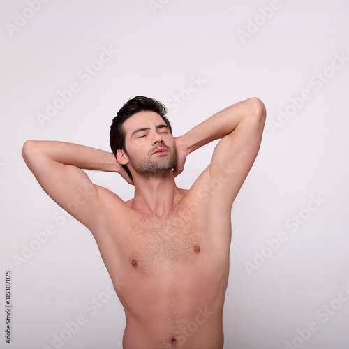 Handsome sexy man posing isolated on grey.