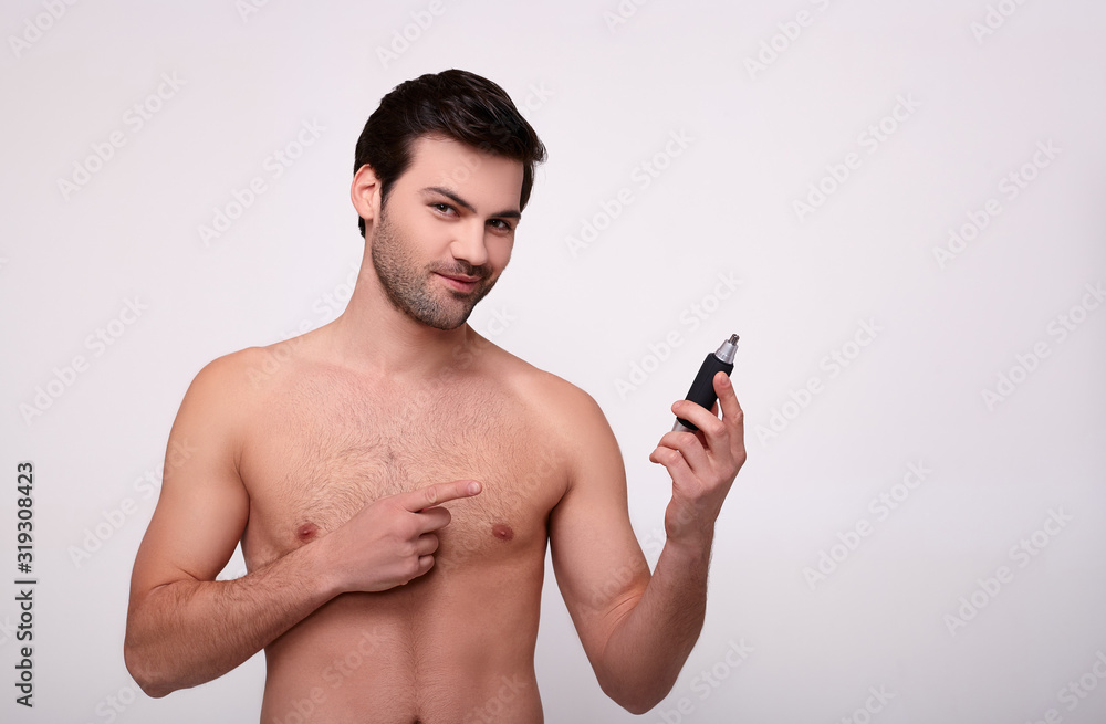 Fototapeta premium Charming handsome shows on the trmmer in his hand.