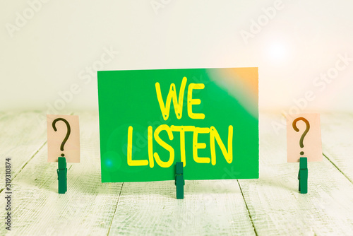 Word writing text We Listen. Business photo showcasing Group of showing that is willing to hear anything you want to say Scribbled and crumbling sheet with paper clips placed on the wooden table photo