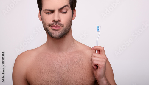 A cropped frame, a Caucasian guy with a toothbrush.