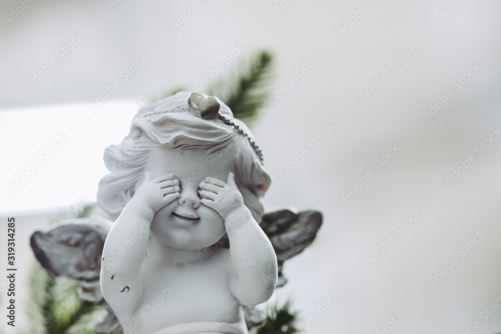 Fototapeta premium Figurine en terre représentant un ange qui cache ses yeux