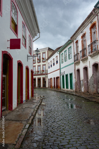 Vertical urban landscape with narrow street  colorful houses and cobbled pavements in Ouro Preto city  Minas Gerais - Brazil. Ouro Preto was designed a World Heritage Site by UNESCO in 1980