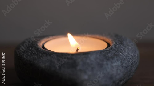 Heart shaped candle t-light flickering on an oak coffee table