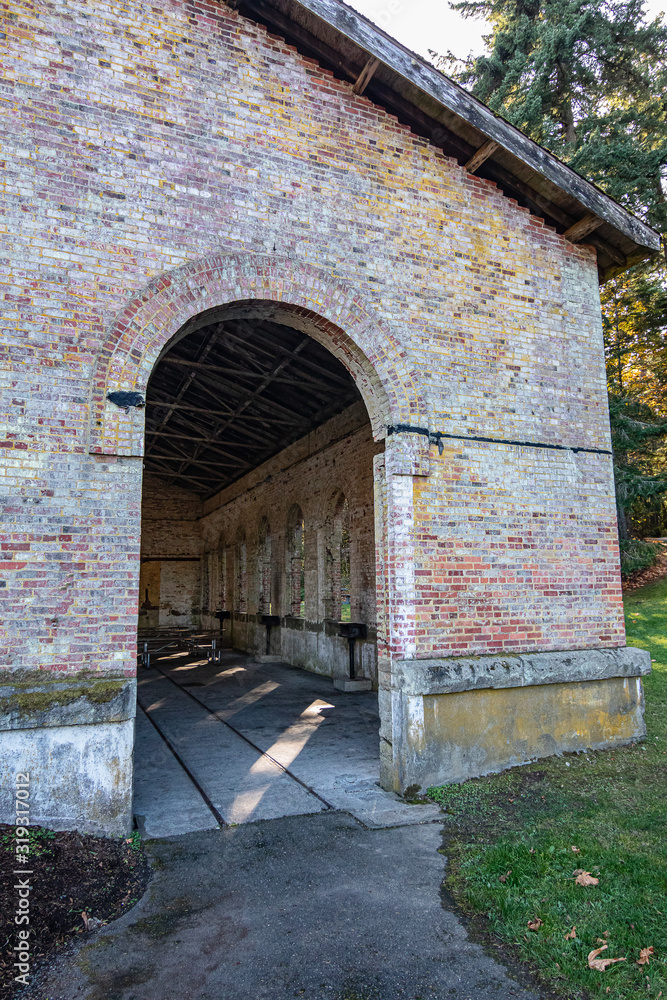 An old brick millitary building in a park used for a picnic area An old brick millitary building in a park used for a picnic area