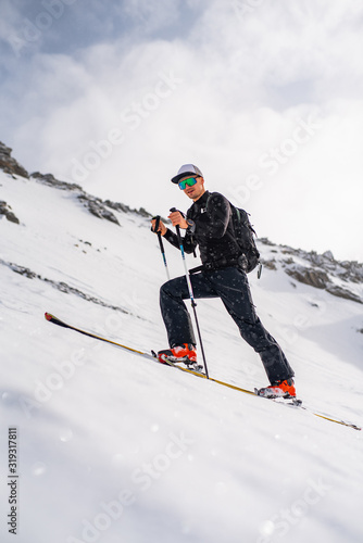 The skituring man, backcountry skiing in fresh powder snow.