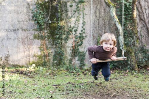 jeune garçon joue sur la balançoire photo