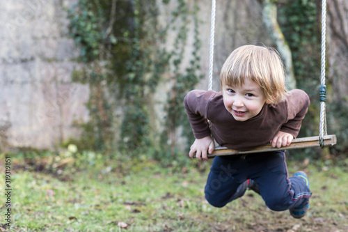 jeune garçon joue sur la balançoire photo