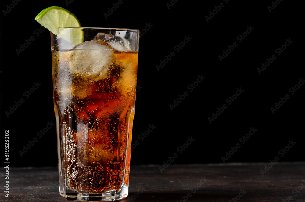 soda or cocktail with ice on table against black background soda or cocktail with ice on table against black background