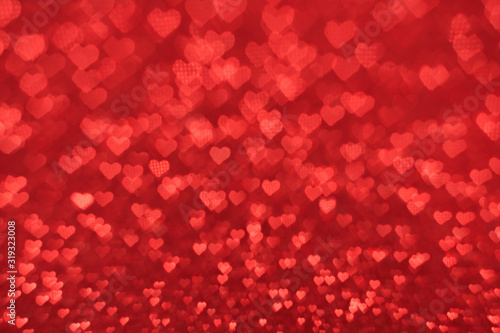 The bokeh texture in the form of many small hearts on a red background. Valentine's day concept.