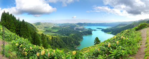 Panorama of the volcanic caldera at Sete Cidades on São Miguel in the Azores. The Azul and Verde lakes show their blue and green waters with Yellow Ginger (Hedychium gardnerianum) in the foreground.