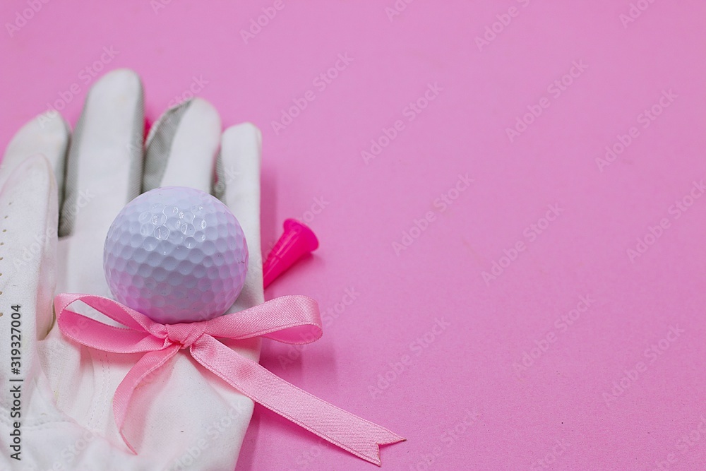Golf ball and pink ribbon are on pink background