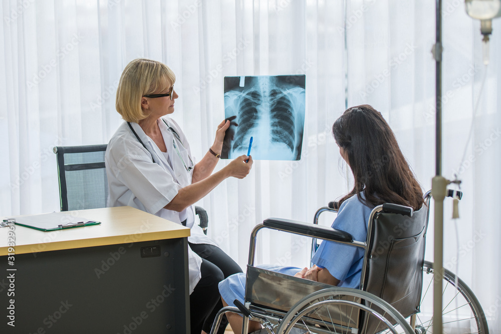 The female doctor is explaining the details of the patient's x-ray film. The female doctor is explaining the details of the patient's x-ray film.