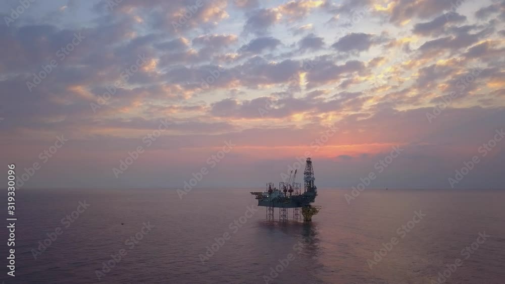 Aerial view of the jack up rig shot during sunset time. Fly around the jack up rig with a drone. Aerial view of the jack up rig shot during sunset time. Fly around the jack up rig with a drone.