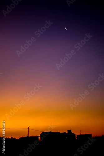 Shadows of houses and the moon in a sunset. © Alberto Camus