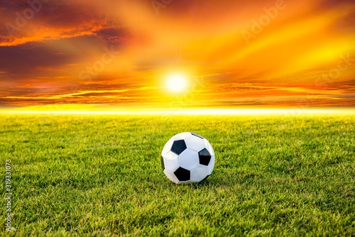 Football or soccer ball at the kickoff of a game with sunset  © yaalan