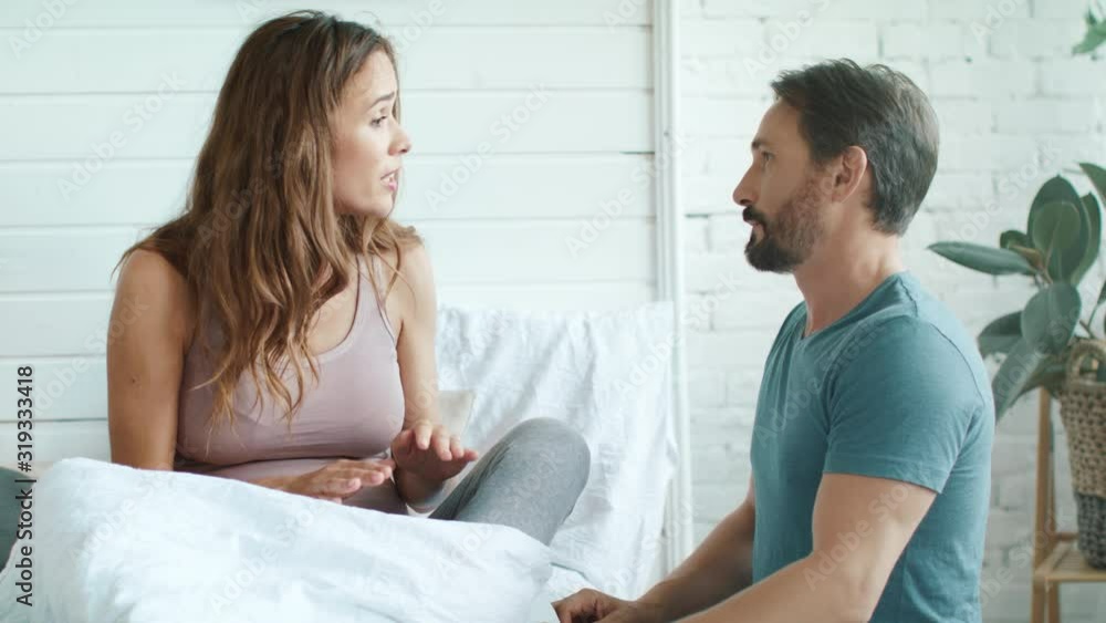 Closeup upset pregnant wife arguing with husband in bedroom. Closeup upset pregnant wife arguing with husband in bedroom.