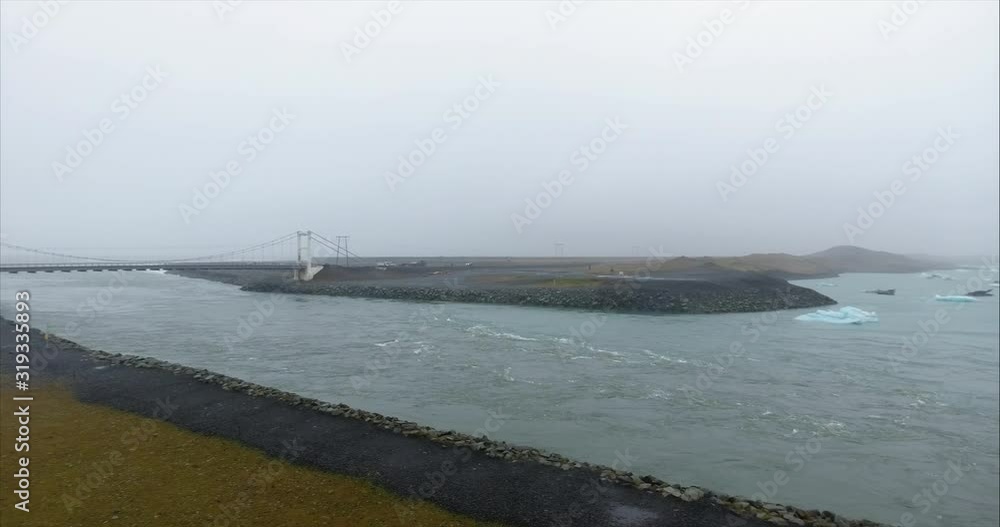 Water flow under a bridge from the ocean to an ice lagoon in Iceland Water flow under a bridge from the ocean to an ice lagoon in Iceland