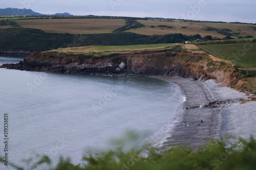 Beach in Wales showing cliffs and rural landscape