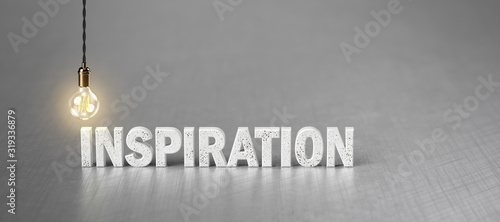 the word INSPIRATION and a light bulb on brushed aluminum background