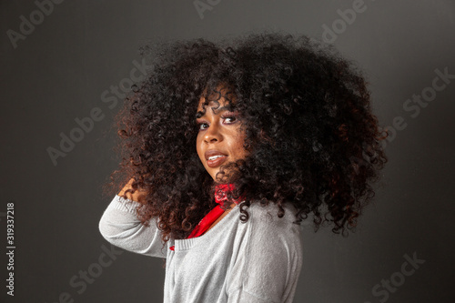 Beauty portrait of african american woman with afro hairstyle and glamour makeup. Brazilian woman. Mixed race. Curly hair. Hair style. Black background.