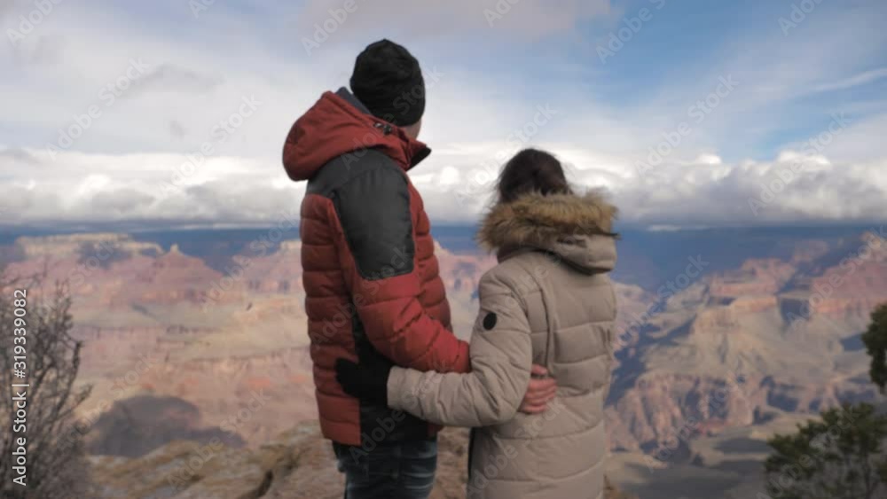 Young travel adventure couple male female share special moment at Grand Canyon Young travel adventure couple male female share special moment at Grand Canyon
