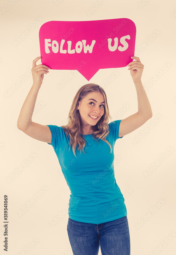 Beautiful young woman holding follow us social media icon for her business on the internet Beautiful young woman holding follow us social media icon for her business on the internet