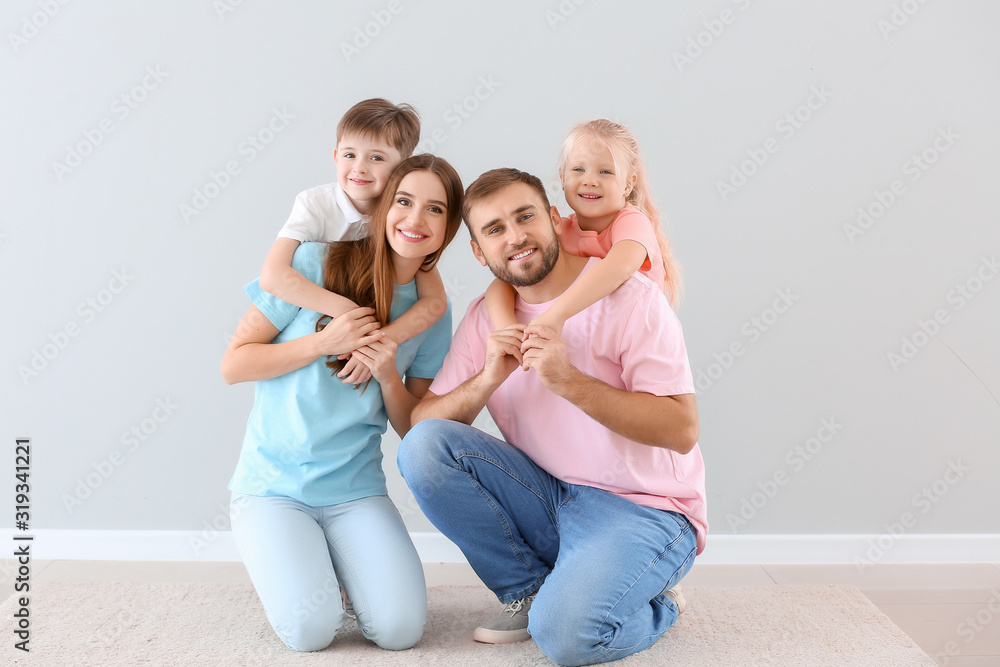 Portrait of happy family near light wall