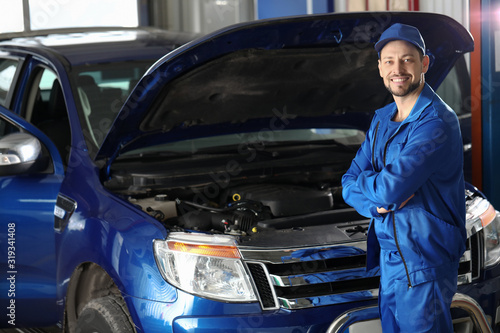 Male mechanic near car in s...