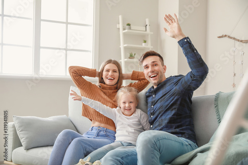Happy young family sitting ...