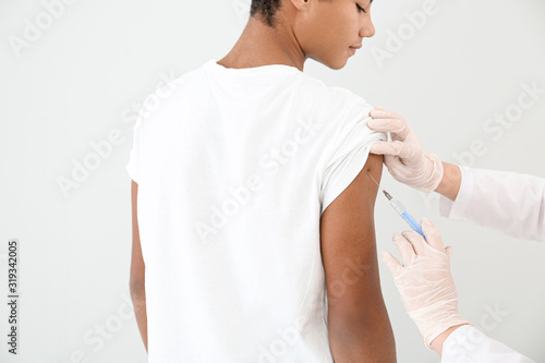 Doctor vaccinating teenage ...