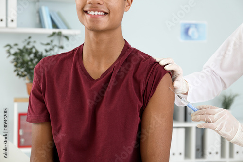 Doctor vaccinating teenage ...