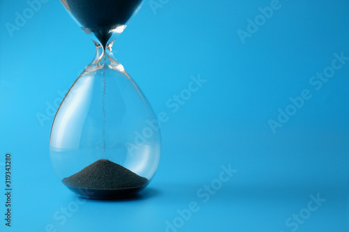 Hourglass on color background. Time management concept photo