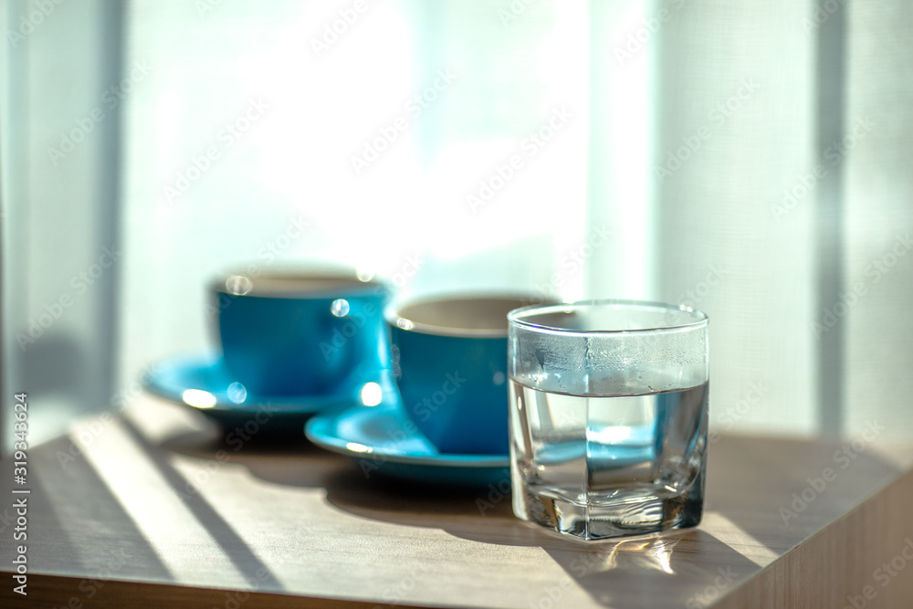 Blurred background view of a mug or coffee cup, a cup of water or a drink on the table, for customer service in a room or restaurant Blurred background view of a mug or coffee cup, a cup of water or a drink on the table, for customer service in a room or restaurant