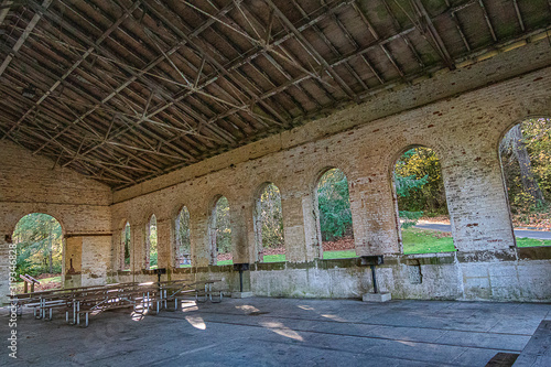 An old brick millitary building in a park used for a picnic area photo