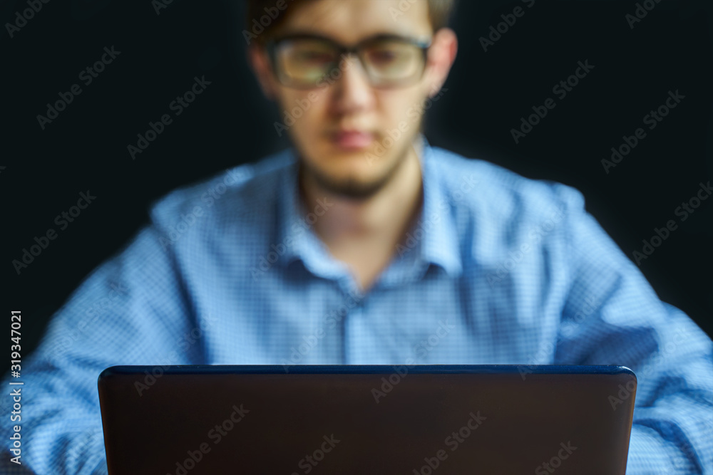 Student learns. Man in glasses working with laptop. Selective focus Student learns. Man in glasses working with laptop. Selective focus