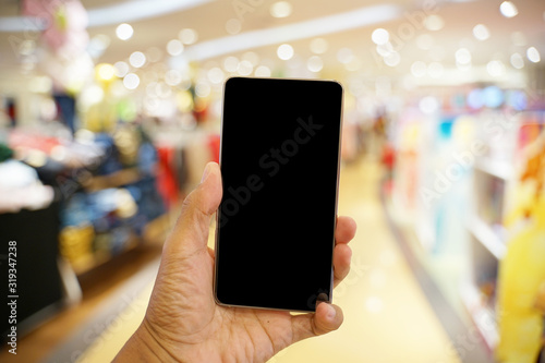 Holding phone with blurry background at mall