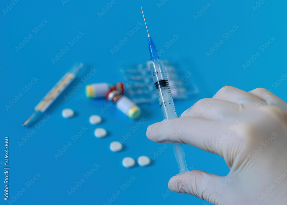 White disposable gloves, syringe with vaccine and medicine. Hygiene and protection against diseases and viruses. Coronavirus..Flu White disposable gloves, syringe with vaccine and medicine. Hygiene and protection against diseases and viruses. Coronavirus..Flu