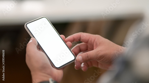 Cropped shot of young male using his blank screen smartphone  with relax sitting position © bongkarn